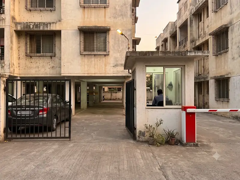 Apartment building entrance with a gate, security cabin and boom barrier